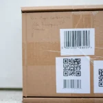 Cardboard shipping box with barcode and QR code labels