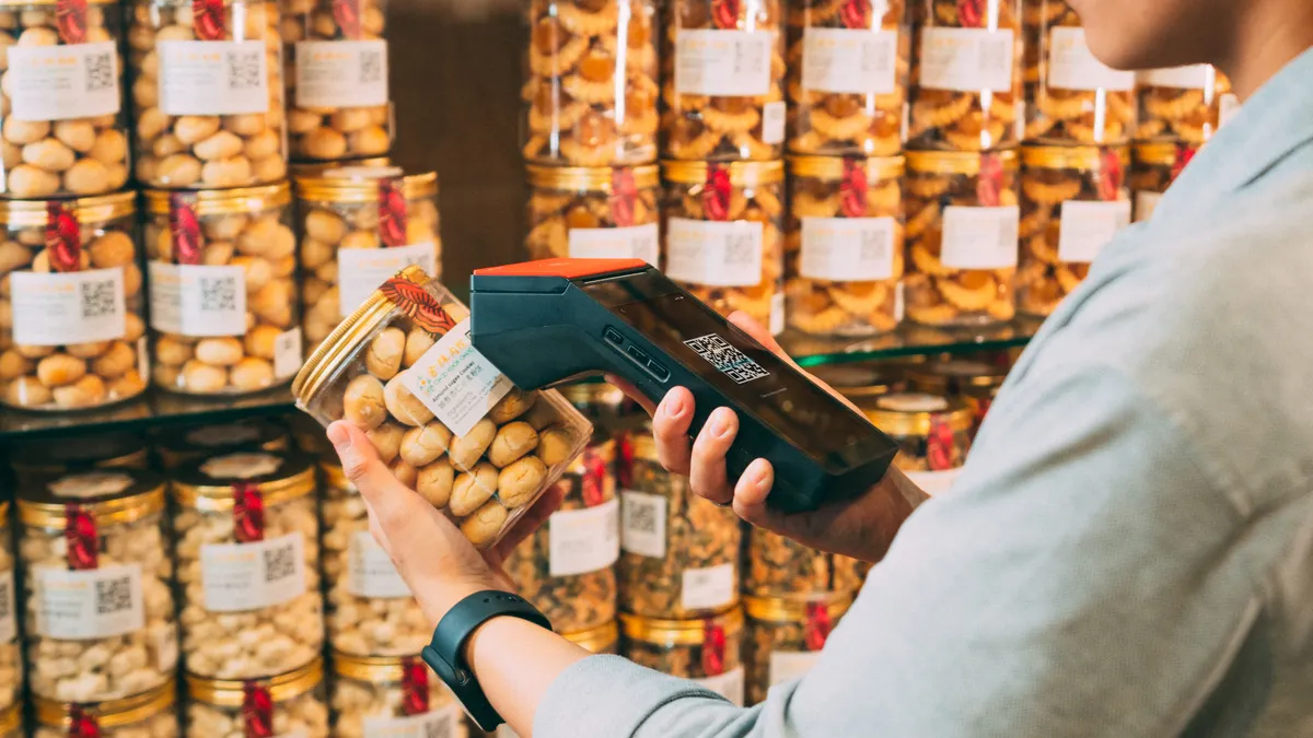 Person scanning packaged jars in a grocery aisle