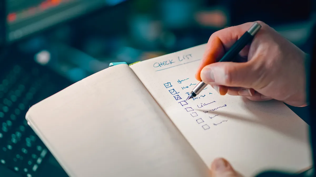 Hand checking boxes in a notebook