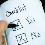 Hand ticking a checklist on paper