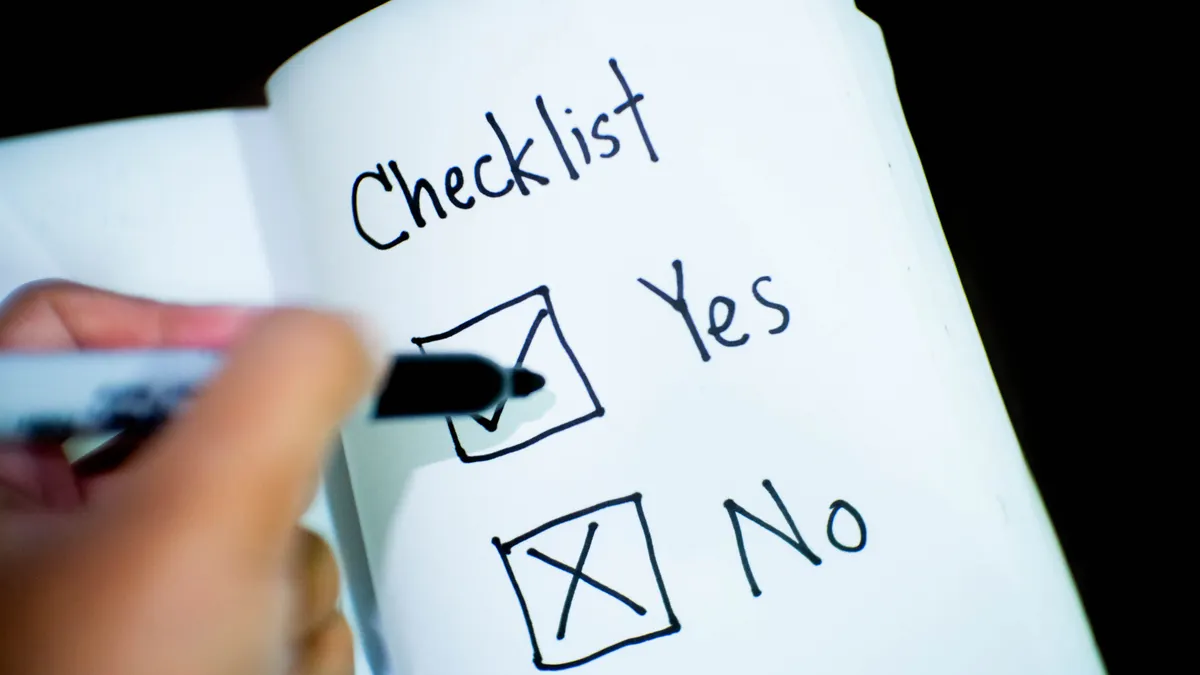 Hand ticking a checklist on paper