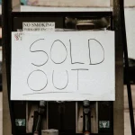 Handwritten SOLD OUT sign on a storefront pump