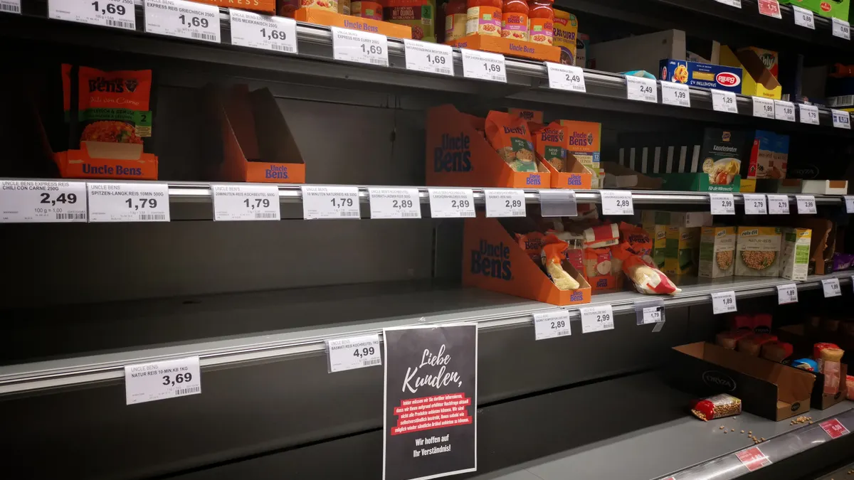 Mostly empty supermarket shelf with a few items