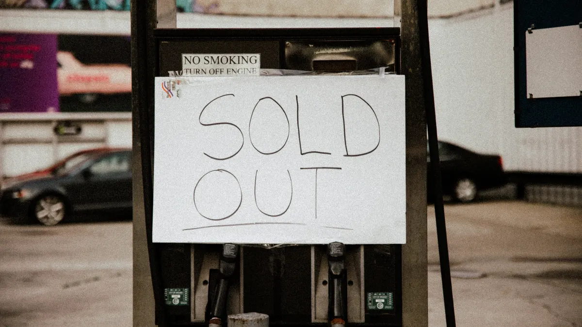 Handwritten SOLD OUT sign on a storefront pump